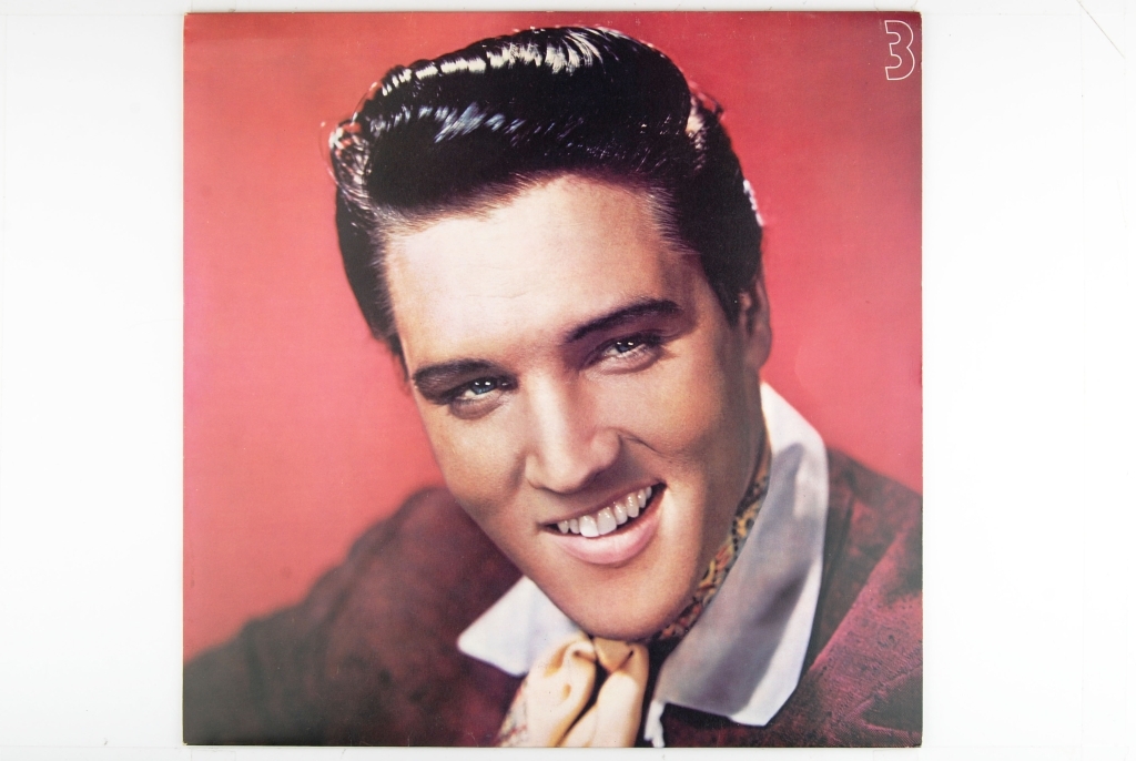 Bilde av Elvis Presley. Synger og har en gitar rundt livet.