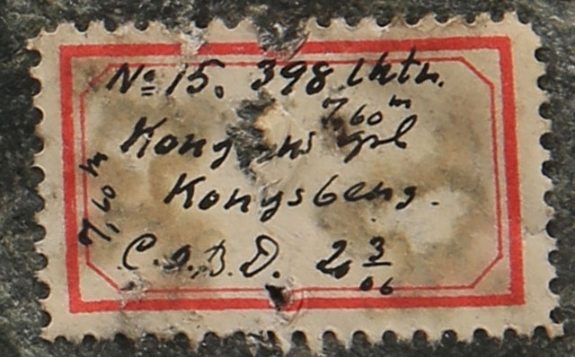 Tekst på etikett:
No 15. 398 lktr.
7,60m
Kongens grb.
Kongsberg
C.O.B.D. 20/3 06