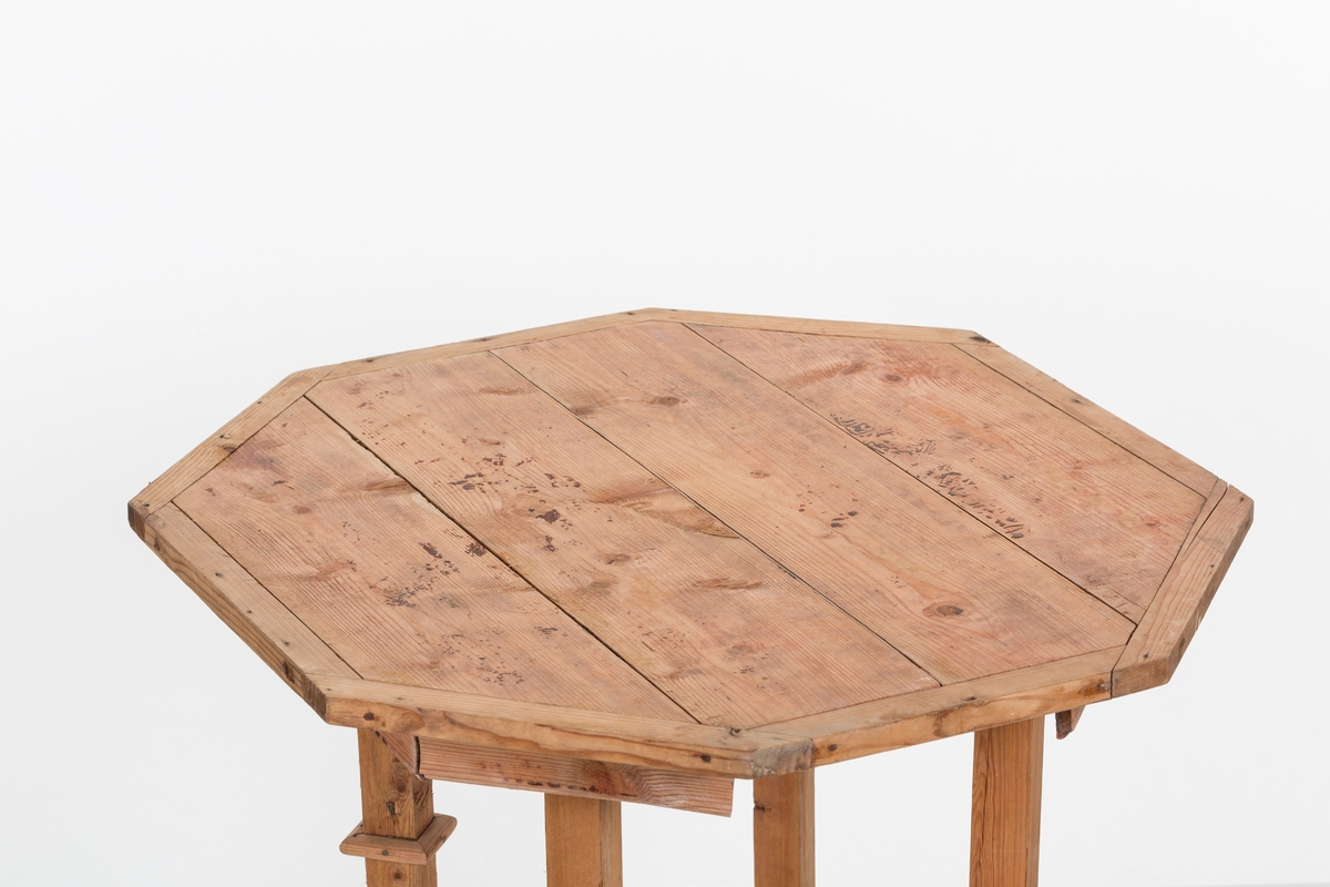 Åttekantet bord. Sprosser i kryss mellom beina. Bordplata er satt sammen av 4 bord i ramme.
