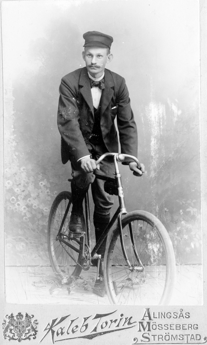 En man sitter på en cykel.