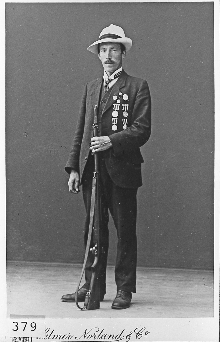 Asle Hagen med skyttermedaljer og gevær. Ca. 1910.