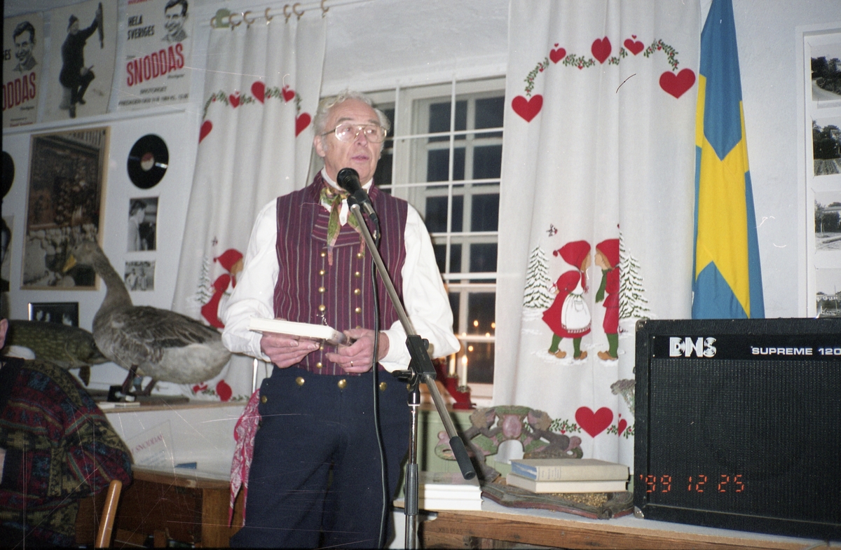En man klädd i hembygdsdräkt talar vid öppningen av Bollnäs-kistan, juldagen 1999.