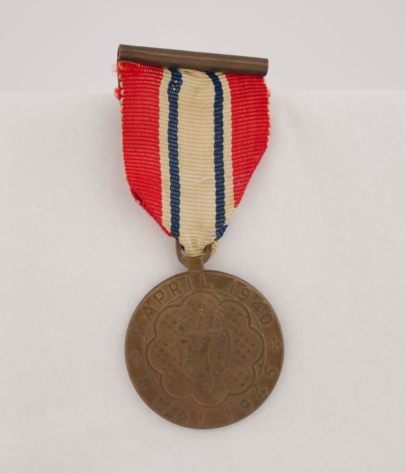 Medaljen i bronse. På adversen er Norges riksvåpen med omskriften «9 APRIL 1940 * 8 MAI 1945 *». På reversen er kongeflagget, handelsflagget og orlogsflagget. Over disse en smal sirkel med innskriften «DELTAGER I KAMPEN». Motivet er omgitt av en lenke. Bånd i rødt, hvitt og blått.