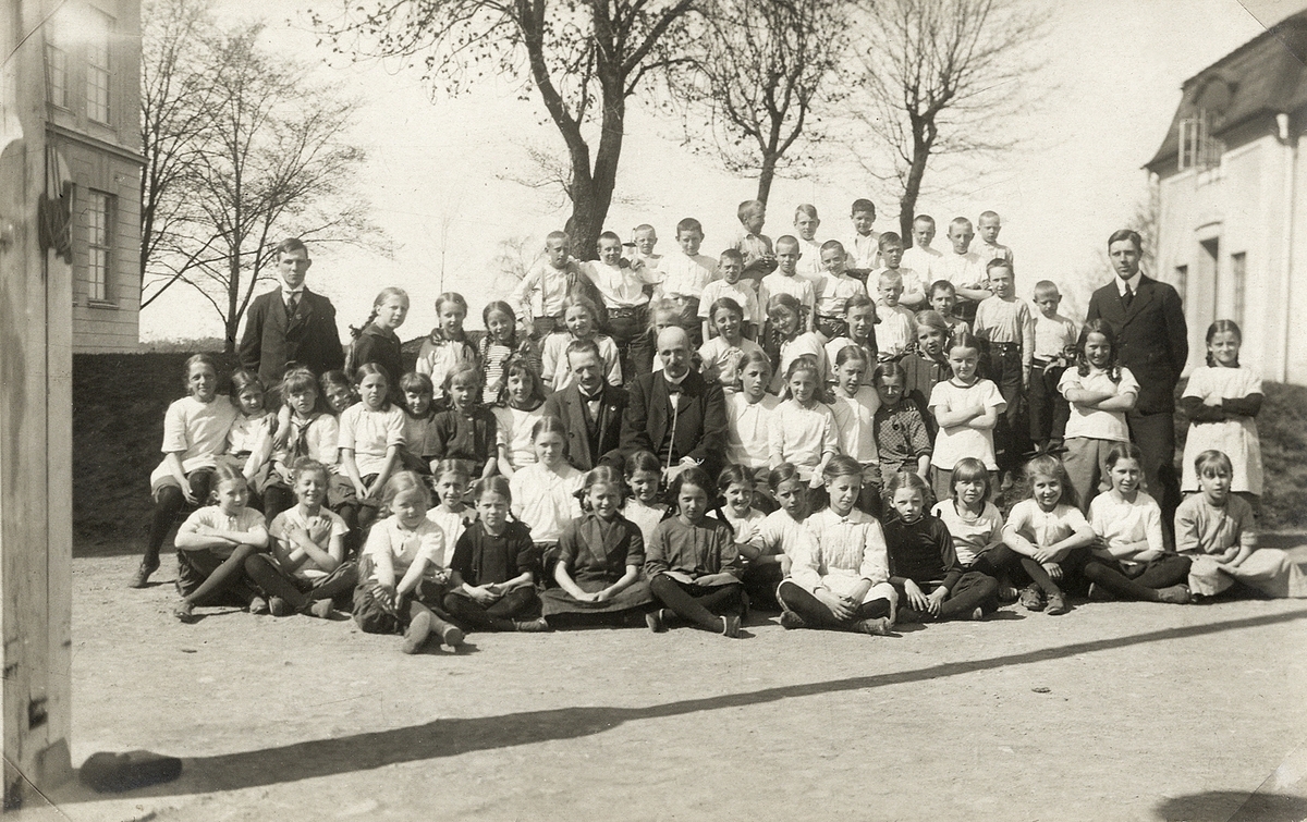 Folkskoleseminariet, Ringsbergsskolan, Växjö, ca 1918. 
En stor grupp elever har samlats på skolgården med några lärare, däribland (i mitten) gymnastikdirektör Nils Danckwardt och rektor Samuel Mårtensson (rektor för seminariet från 1916).