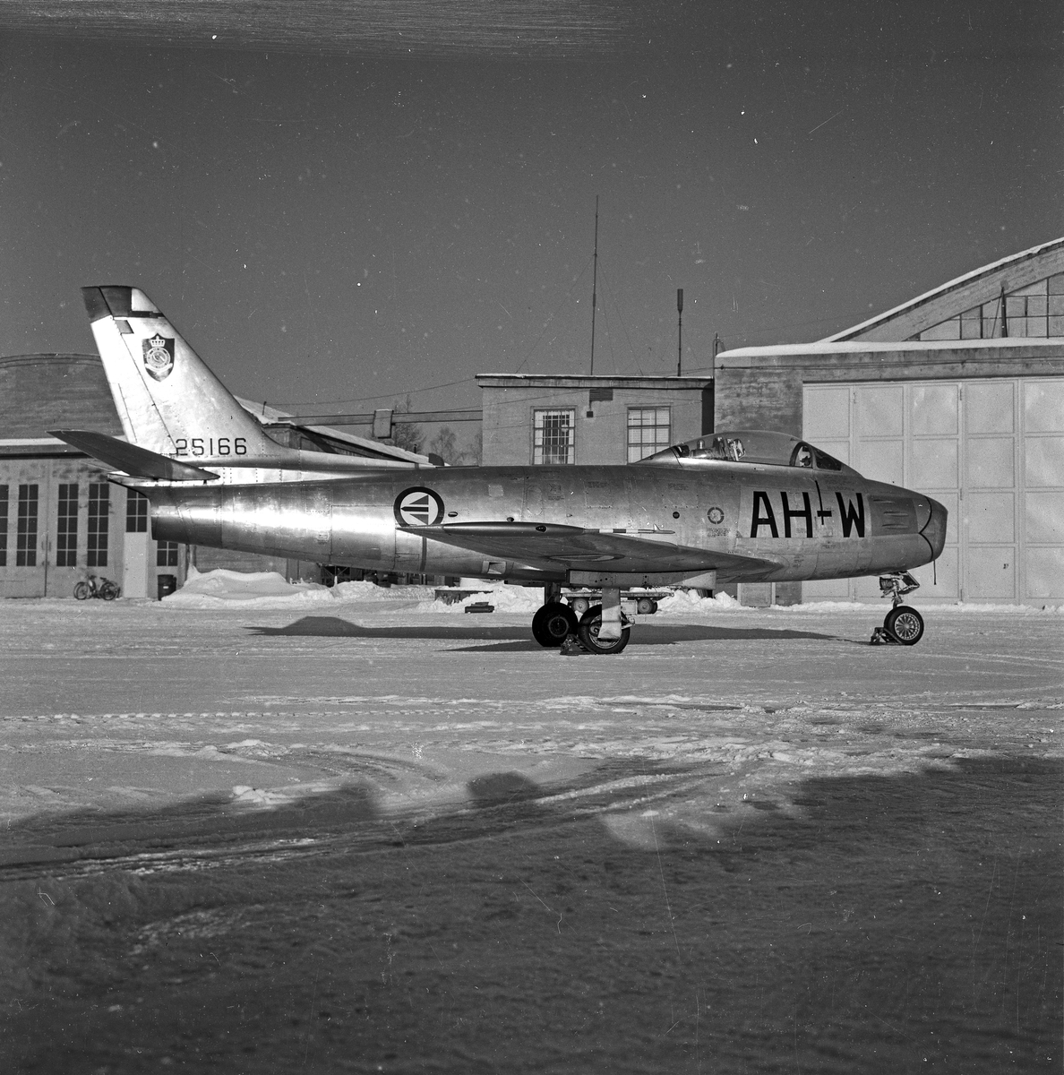  North American F-86F Sabre, litt skrått bakfra foran hangarer.