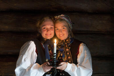 To dmenr i bunad holder et lys. Foto/Photo