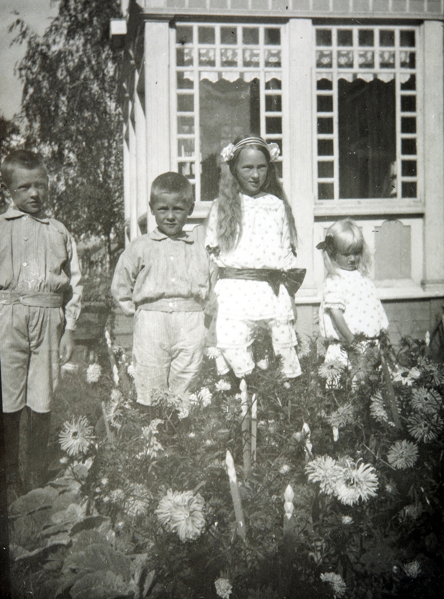 Gruppe 4 barn i hagen ved Ottestad Gård, Stange. Fra venstre: Gustav, Odvar, Valborg og Eli Gjerstvang.