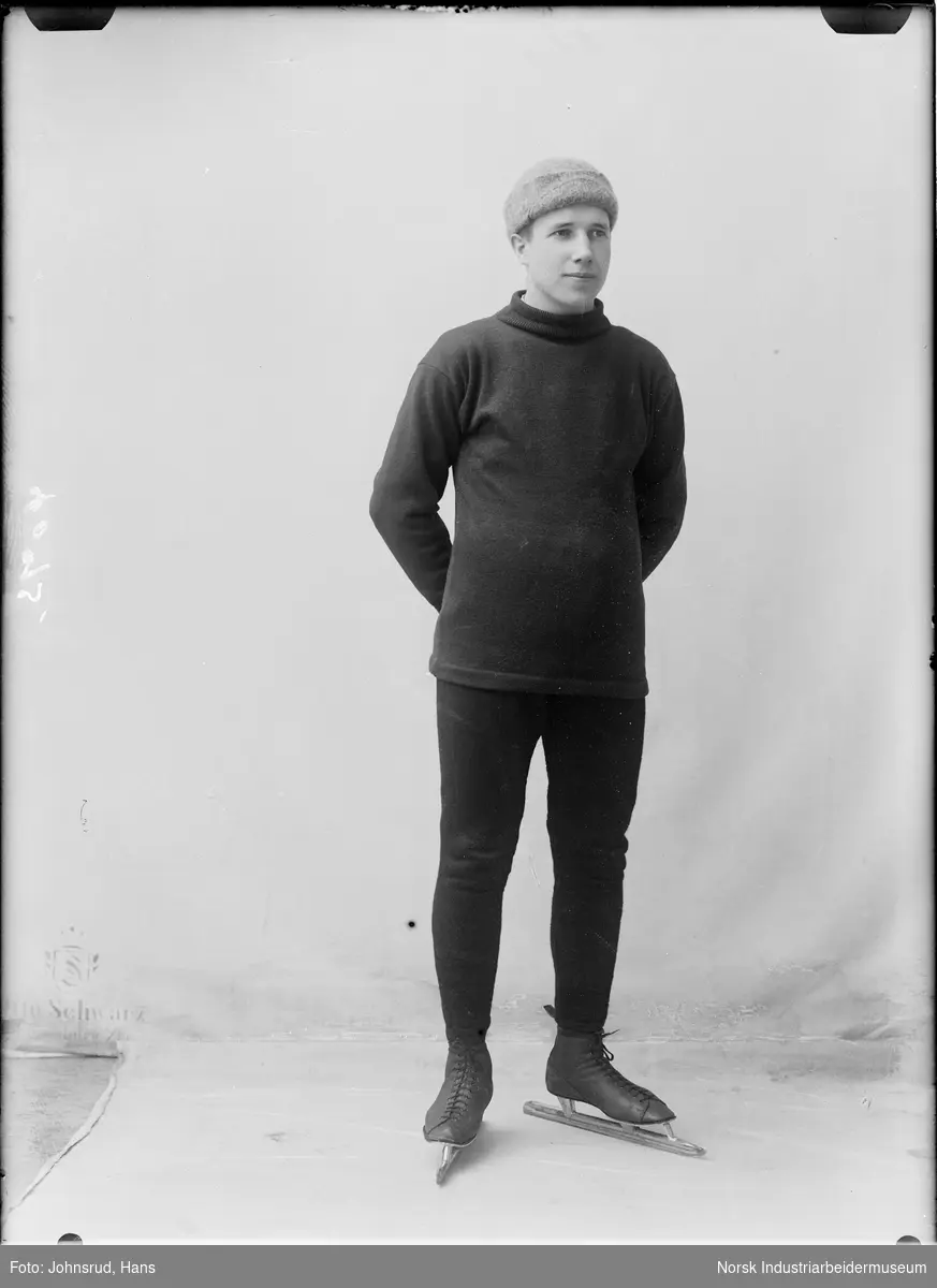 Portrett av mann med lue stående med skøyter.