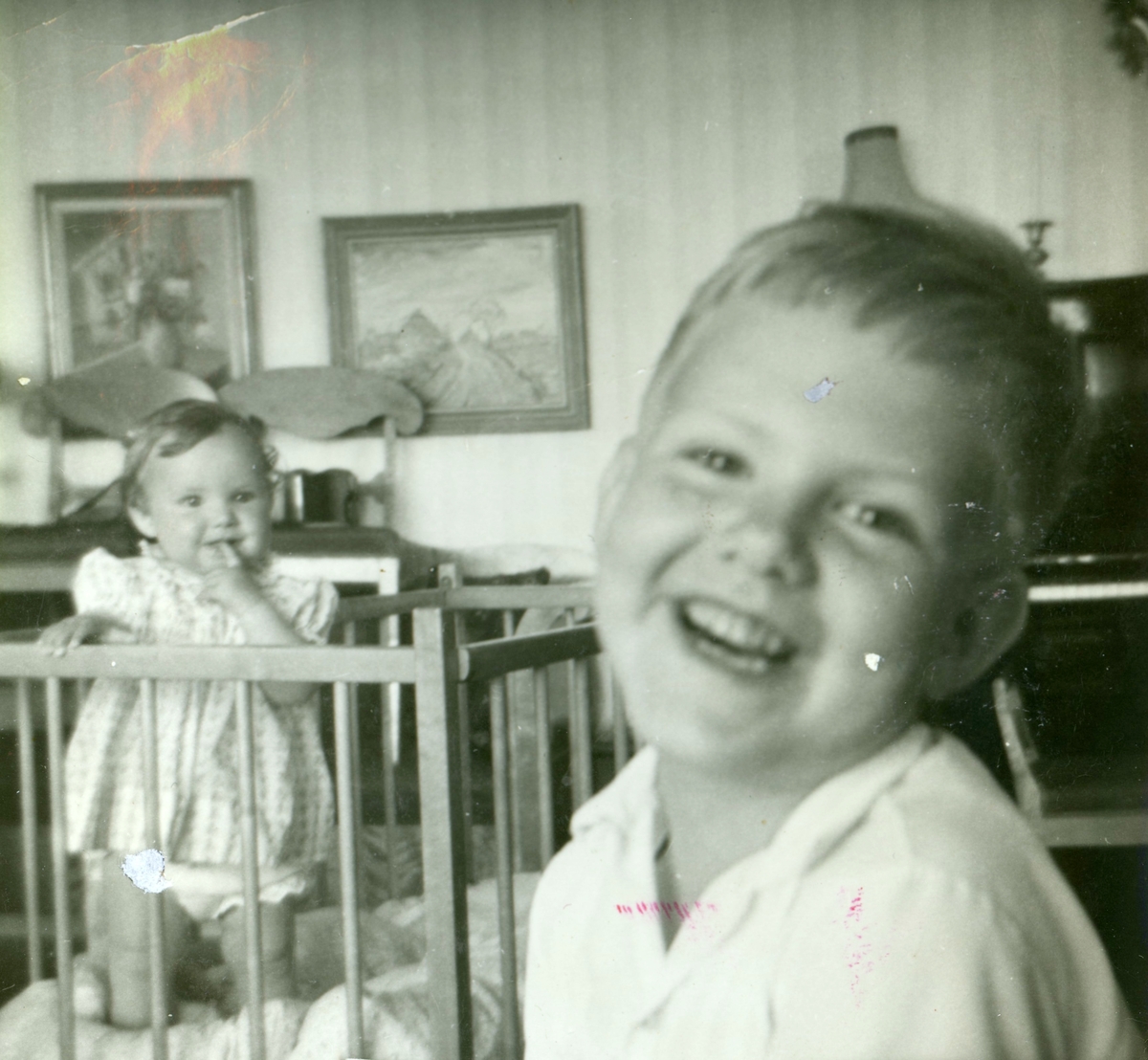 De två små syskonen, Eva-Maria Samelius (född 1960) och Pär-Ola (född 1955), befinner sig i vardagsrummet i Rothvalls cirka 1960. Familjen Samelius hyrde en lägenhet hos Elin Rothvall på Streteredsvägen 31 i Vommedal Östergård.
