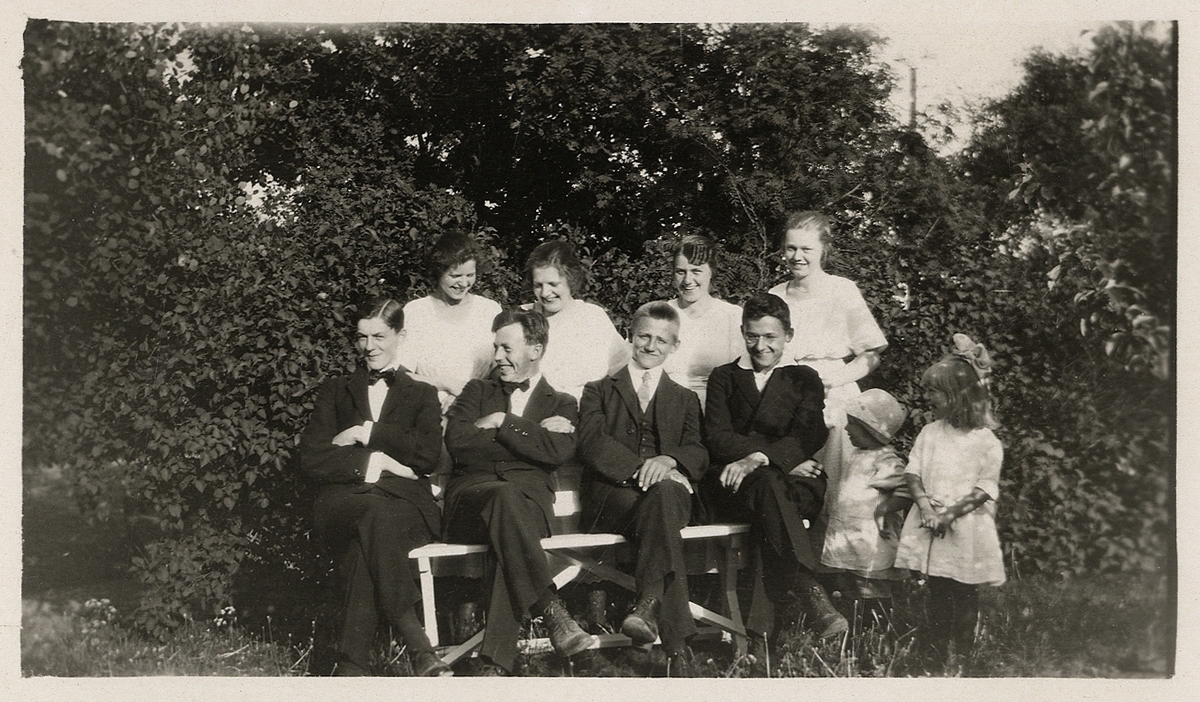 En grupp ungdomar och två småflickor har samlats i en trädgård, ca 1920.
Herrlin, Åseda (?).