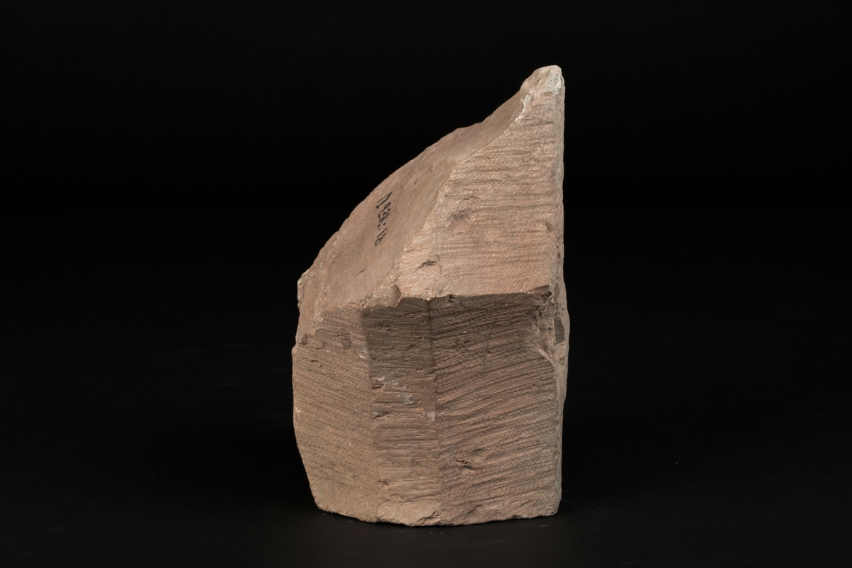 Del av masverk tillverkad av kalksten.
Stenen är huggen med tandjärn. Fragmentet saknar fals för fönsterbågar.