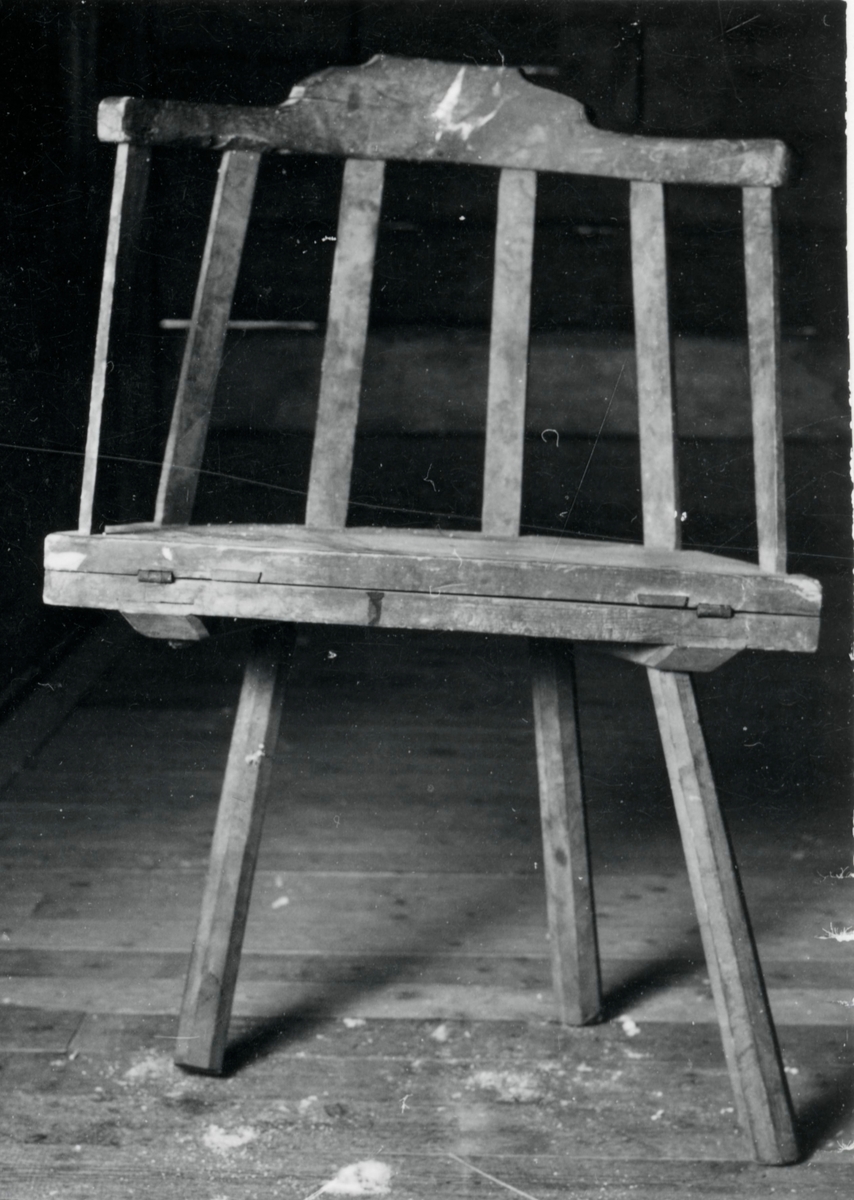 Brunmålad stol sk bordstol med 4 st 8-kantiga utställda ben, halvcirkelformad sits, svängt ryggstöd med 6 st spjälor.
Neg nr 81/1063:9