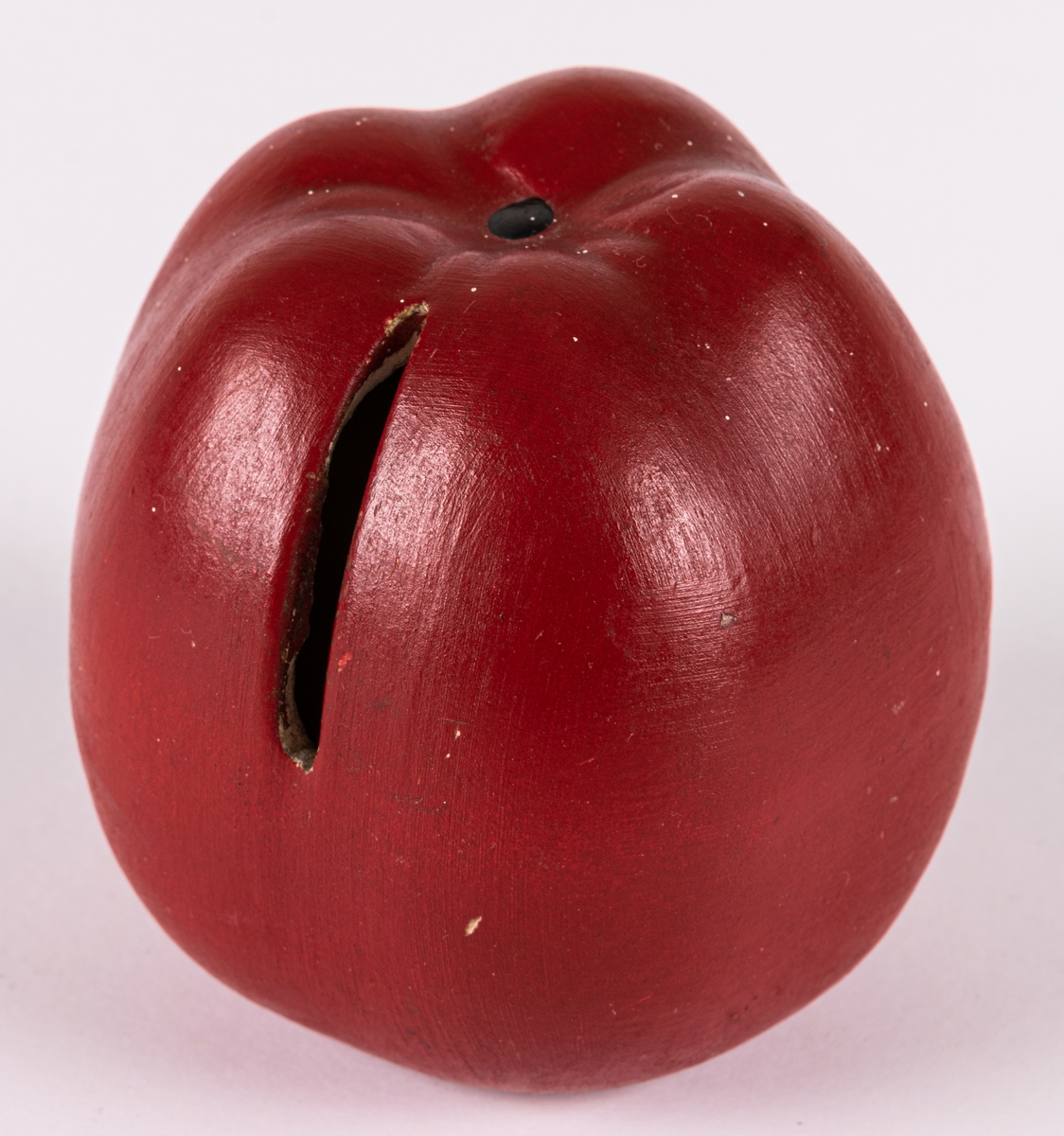 Sparbössa i form av ett rött äpple, tillverkad vid Bo Fajans. Modellen finns med i priskuranter från 1920-talet och framåt. Just denna sparbössa är med mycket hög sannolikhet tillverkad under första hälften av 1940-talet då det gavs bort som gåva 1946 eller 1947. Se vidare under Historik.