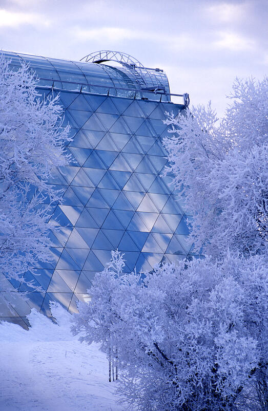 Vinterbilde av Hamardomen; rimede trær omkranser glassbygget som gjengir mange ulike blåtoner. (Foto/Photo)