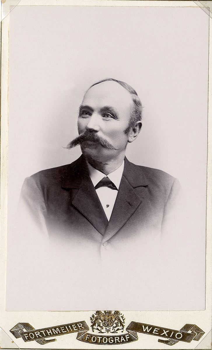 Porträttfoto av järnsvarvare (senare vattenledningsentreprenör) Carl Sjögren (1848-1919), Växjö. 
Bröstbild, halvprofil, ateljéfoto. Ca 1900.