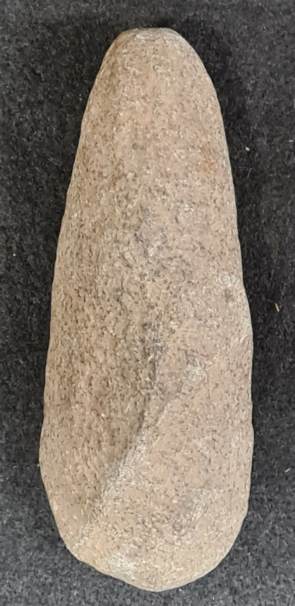 10 555:Från Lilla Hallebo, Flo socken, Västergötland.

Trindyxa, 1st, oval genomskärning. Trubbig nacke, rundad egg. Vittrad. L. 12,4 cm br. 4,8 cm.