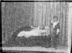 To personer på en scene, jenten til venstre ligger på en sof