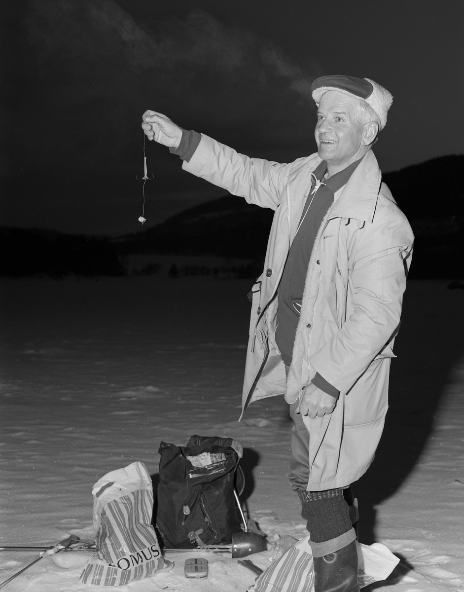 Ole Birkely fra Brumunddal fisker lake under isen i Furnesfjorden, Mjøsa. Han brukte en pilk han hadde støpt hjemme. Under pilken brukte han en fortom av metall med krok og agn. Som agn brukte han krøkle eller lagesild (lågåsild).