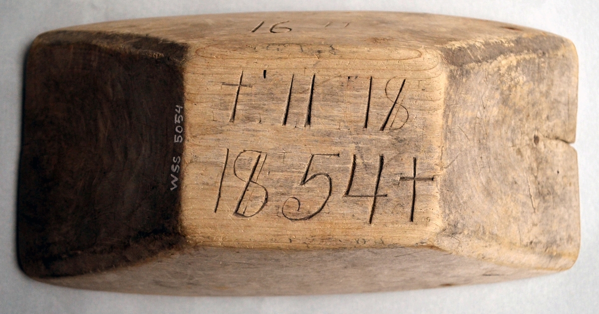 Litet tråg tillverkat i trä, träslag okänt. Tråget är märkt på sidan med siffrorna 16 och sedan troligen ett bomärke som ser ut som 17. Under tråget finns inskriptionen + 11 /8 1854 + som förmodligen är tillverkningsdatum. Tråget är i gott skick men har två sprickor i kortsidorna. Inuti är tråget delvis mörkbrunt, troligen en missfärgning från det som förvarats i tråget.