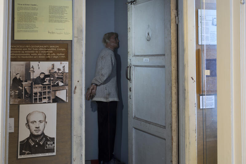 Ein dør inne på Bjørn West museet med nokon bilder av motstandsfolka på venstre side