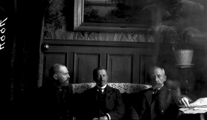 A blurred photograph in an unclear situation. The photograph was taken at the Hotel Phoenix in September 1909. On the left is the Norwegian polar explorer Otto Sverdrup, who also participated in the tribute to Cook. Cook sits in the middle, Roald Amundsen on the right. Photo: Arctic Institute, unknown photographer. (Foto/Photo)