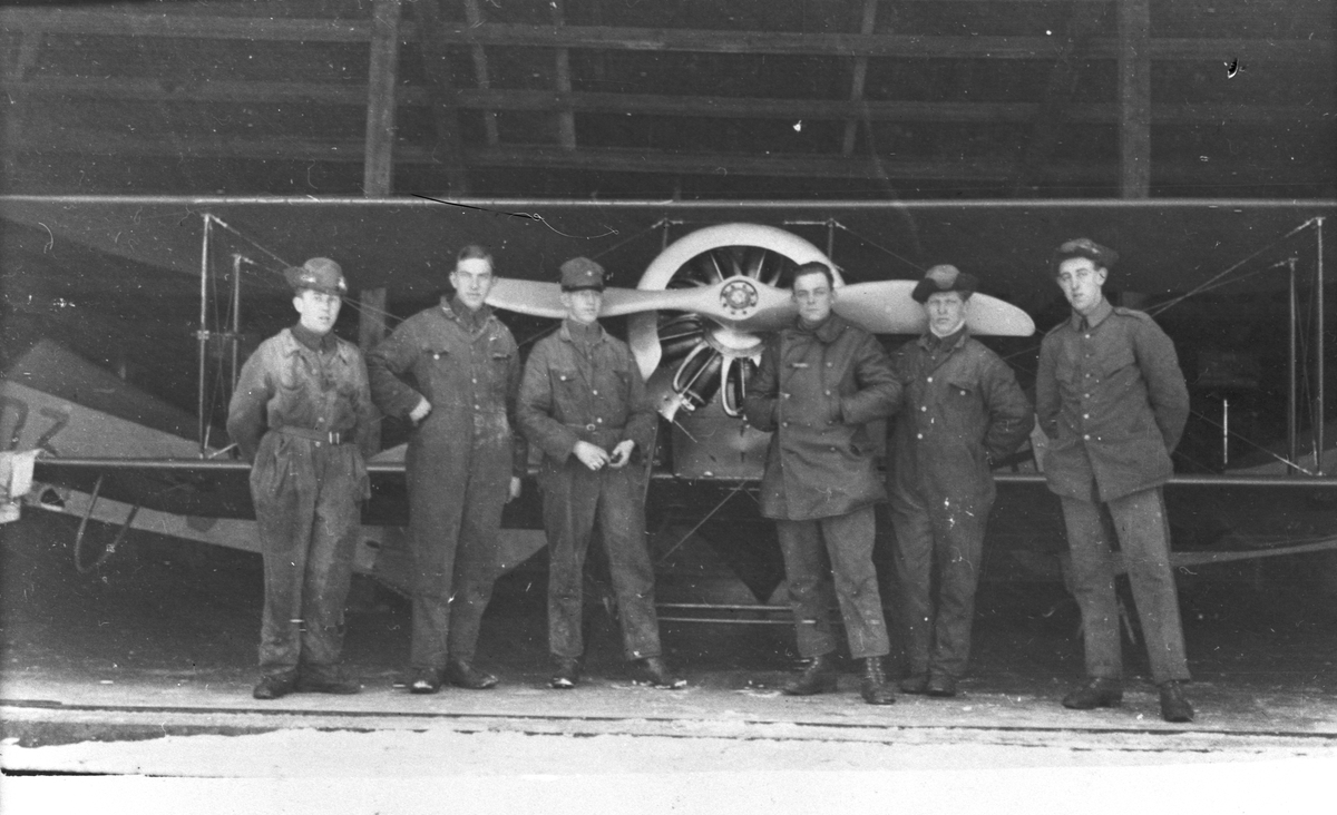 Gruppfoto av sex mekaniker som står framför flygplan Tummeliten, på Malmen, omkring 1927.