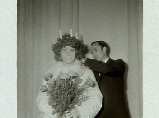 Kröning av 1961 års Lucia, Marianne Lindblom, erhåller Luciasmycket av museichefen Bengt-Arne Person. Artikel i samband med bilderna publicerad i Varbergs Tidning 1961-12-15.