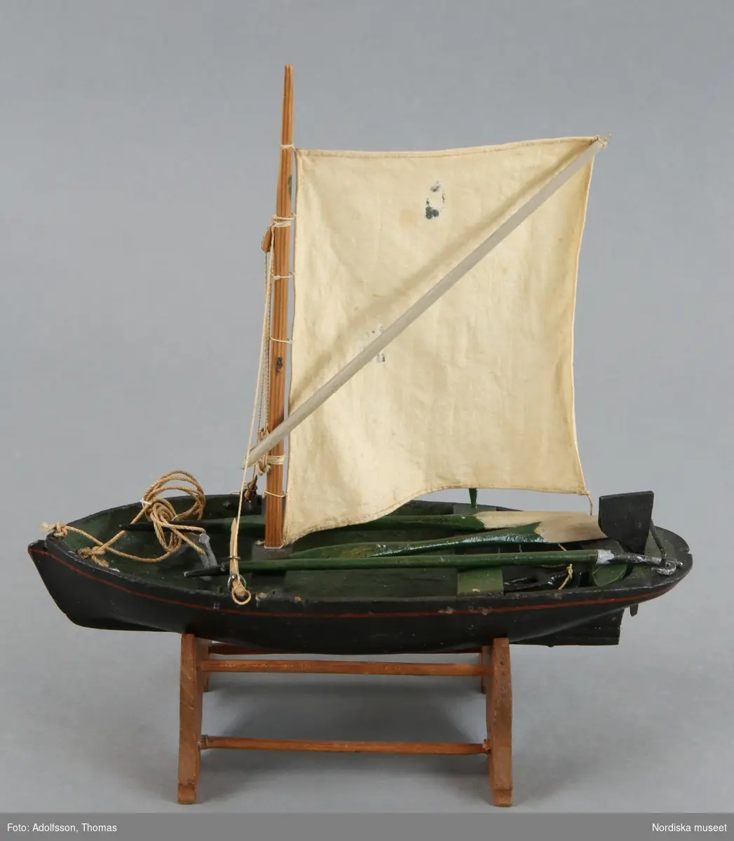Inventering Sesam 1996-1999:
L 20,5, B 9, H 22 cm
Segelbåt "Ellida", av trä, svartmålad utanpå och grön inuti. Ett naturfärgat bomullssegel, ett par åror, en båtshake, ett ankare, ett öskar och ett roder. Båten har två tofter, varav den främre är fäste för masten. Båten står på en träställning. Tillverkades 1858 av nuvarande överlotsen Wirsén på Örö i Kalmar län, vid omkring 15 års ålder. 
Helena Carlsson 1996