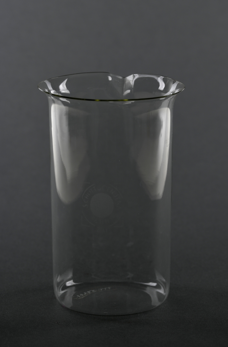Et begerglass av borosilikatglass. Det er sylindrisk med en liten helletut oppe på kanten. Begeret er av typen "Schott Cenjena". Slike glass tåler høy varme, kjemikalier og temperaturforandringer og egner seg til kjemiske eksperiment og lignende. Det rommer 600 ml.