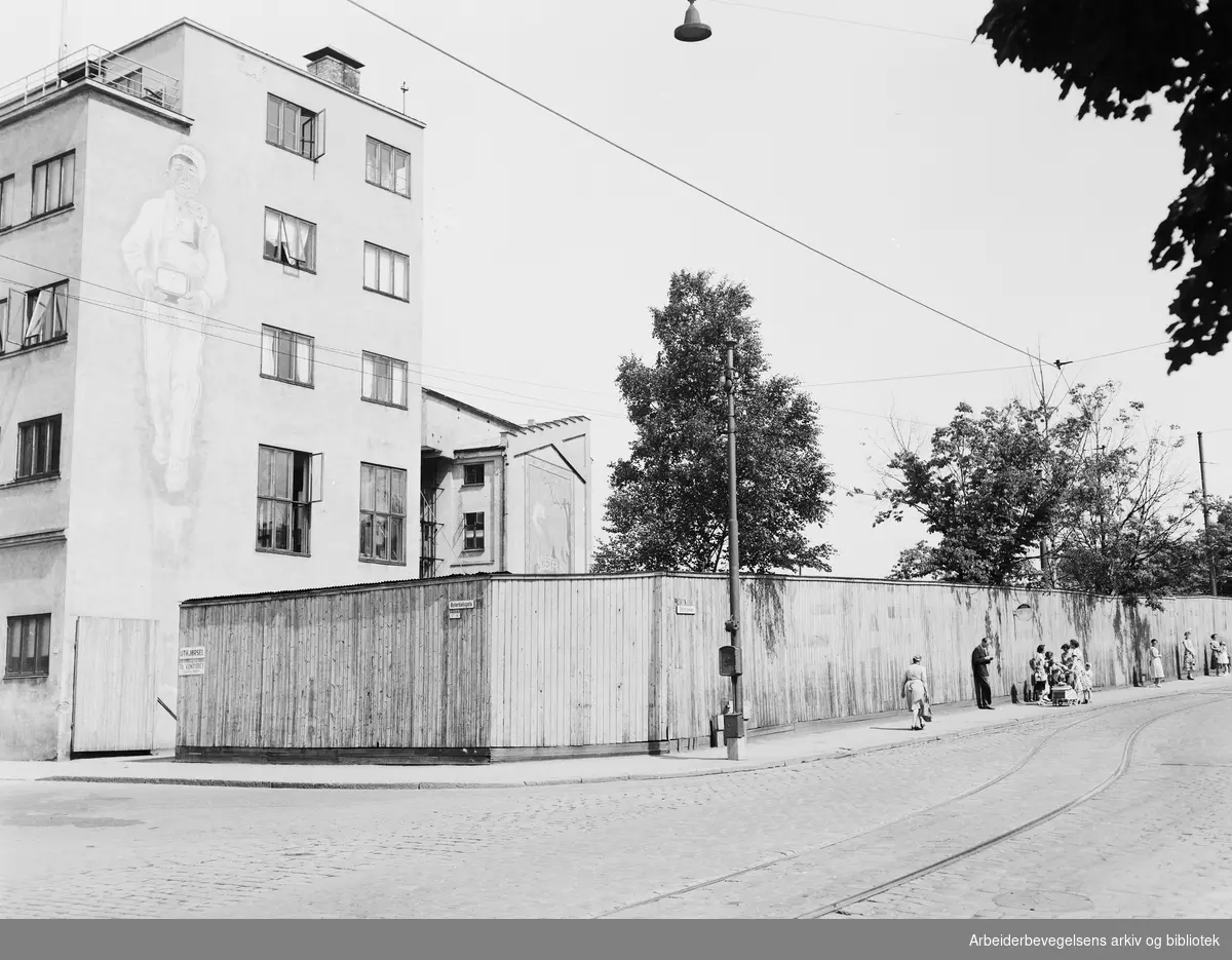 Trikkeholdeplassen ved Sætre kjeksfabrikk på hjørnet av Østerdalsgata og Strømsveien. Juli 1955.