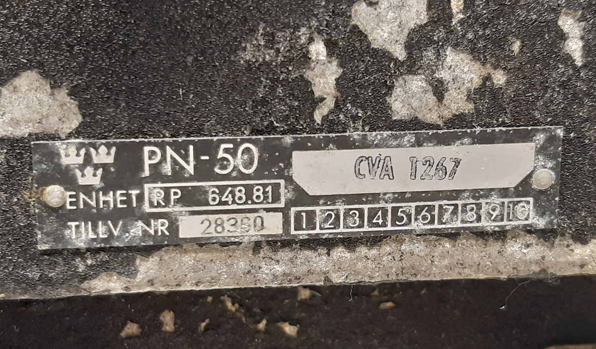 SM-enhet, RP 648.81, till Radarstation PN-50/A. Bestående av en svart låda i metall, med i fronten två stycken stick-kontakter med gul respektive blå markering, samt ett bärhandtag.