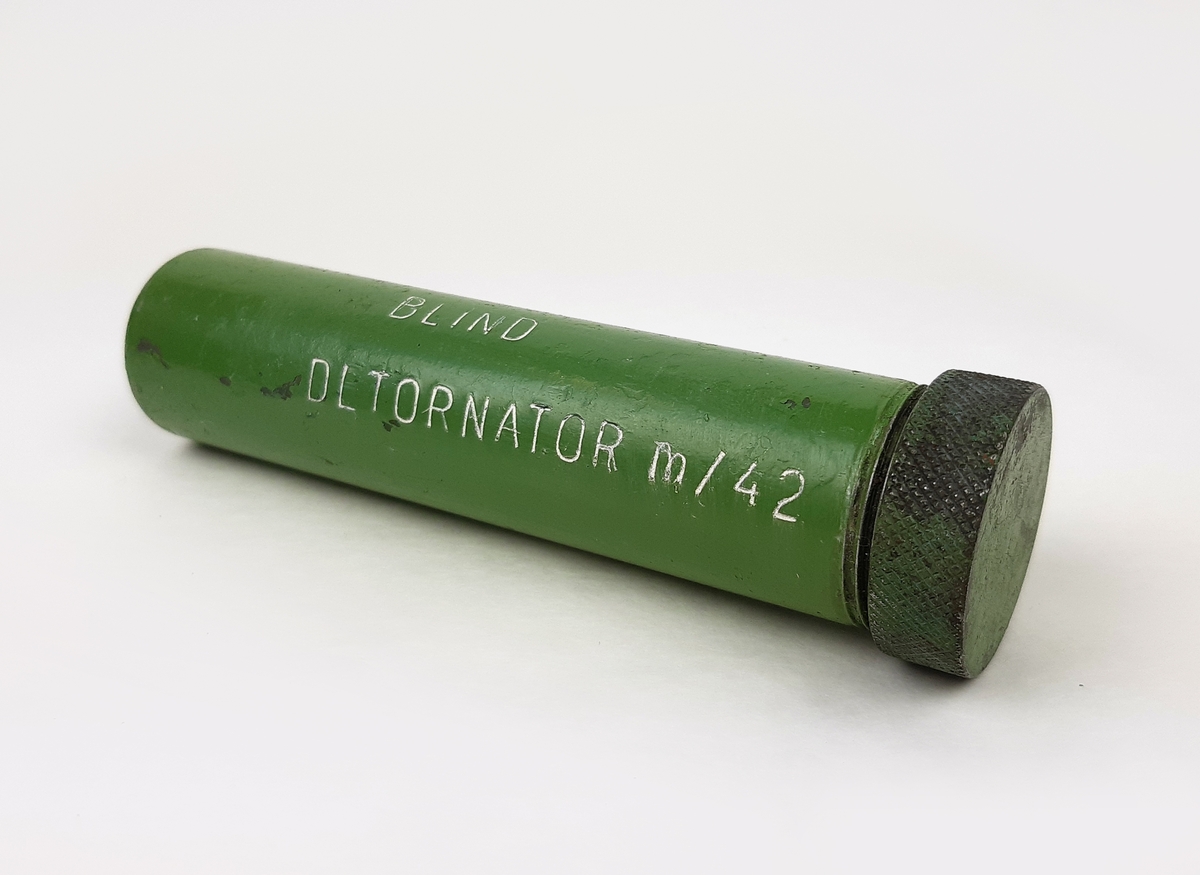 Detonator m/42, blind. Bestående av en grönmålad cylinder i metall med ett skruvbart lock.