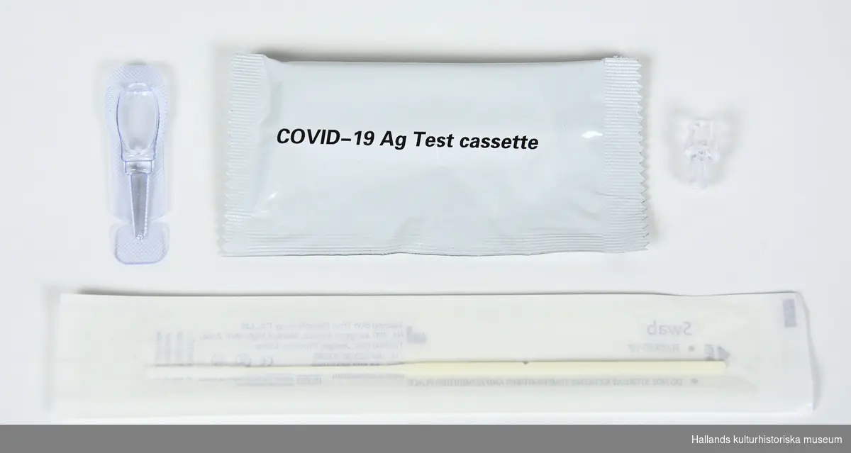 Antigentestför att påvisa pågående infektion av covid-19. Testet består av fyra delar:

A: Pippet av plast med saltlösning, för sköljning av bihålor.

B: Adapter av transparent hårdplast, för att ansluta provtagningspinnen till provtagningskassetten.

C: Covid-19 provtagningskassett.

D: Provtagningspinne av plast med ett vätskeabsorberande material i änden.
