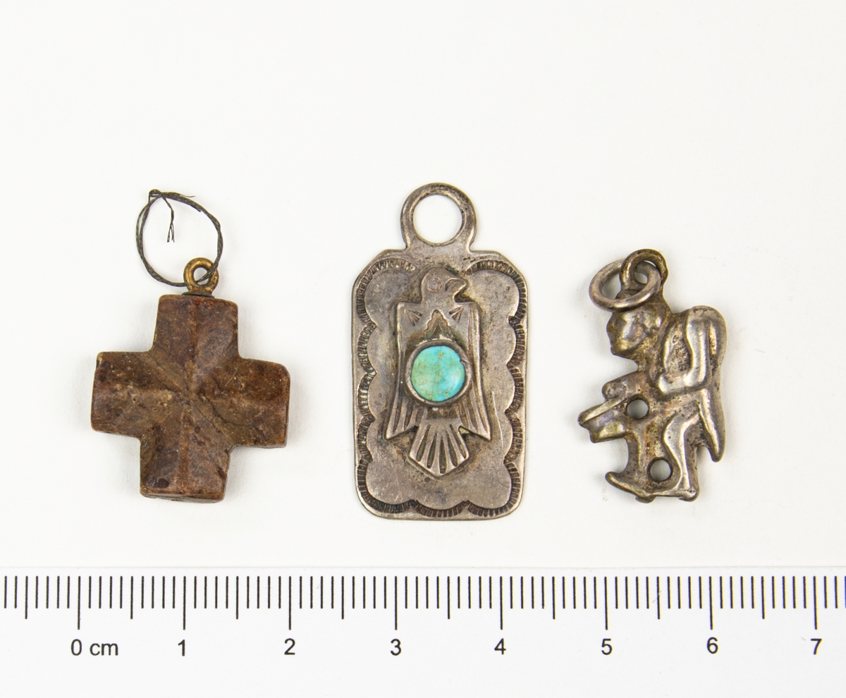 Miniatyrer som förvaras i en rödbrun läderpåse. 
Miniatererna består av en stor blandning av objet; amuletter, souvenirer, berlocker, en tärning med flera.