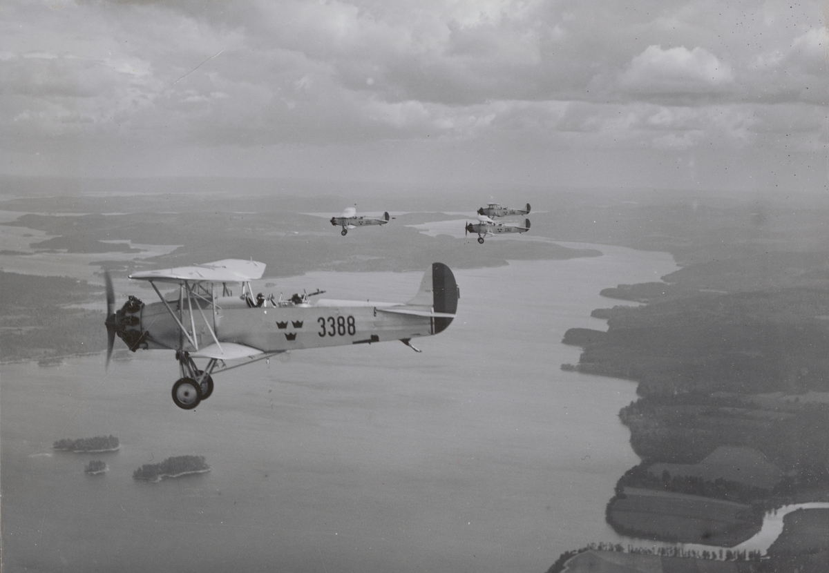Fyra flygplan S 6, Fokker C. VE i luften över landskap, cirka 1930. Flygbild. Flygplan märkt 3337, 33386, 3387 samt 3388.