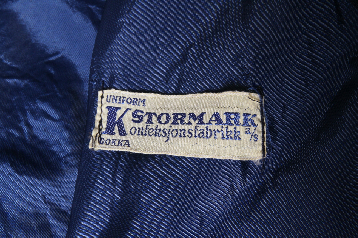 Skjørt og cape i blått stoff av ullblanding. Sydd av firmaet K. Stormark konfeksjonsfabrikk a/s Dokka. Brukt som koruniform i Raufoss damekor. 
