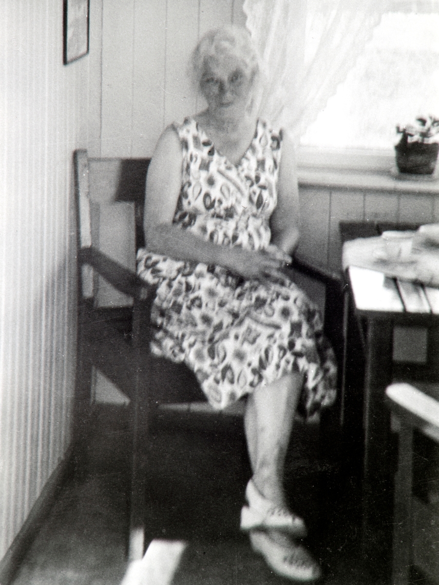 Brita Vikøren sittende å nyter en kaffe kopp på glassverandaen på Stange Barnehjem. Hun jobbet på barnehjemmet.