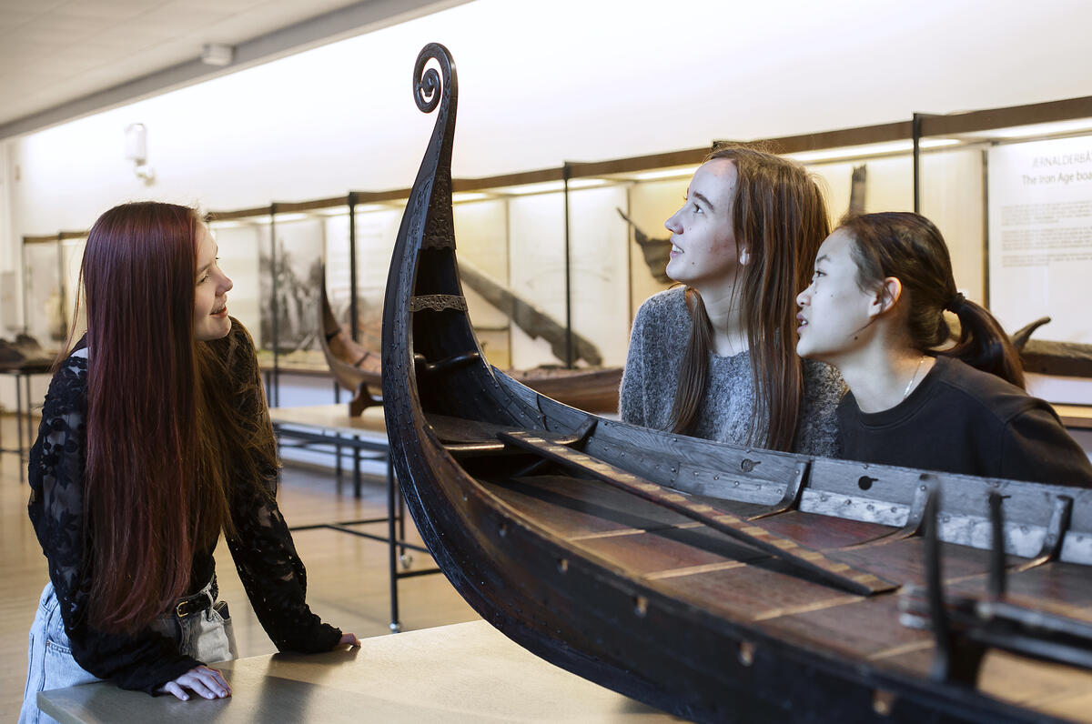 Skoleelever studerer en modell av vikingeskipet Oseberg.
