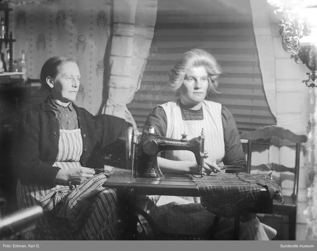 Kristina Regina Eckman tillsammans med en sömmerska som syr på en Singer symaskin, Häre, Indal. Ur Karl Eckmans samling.