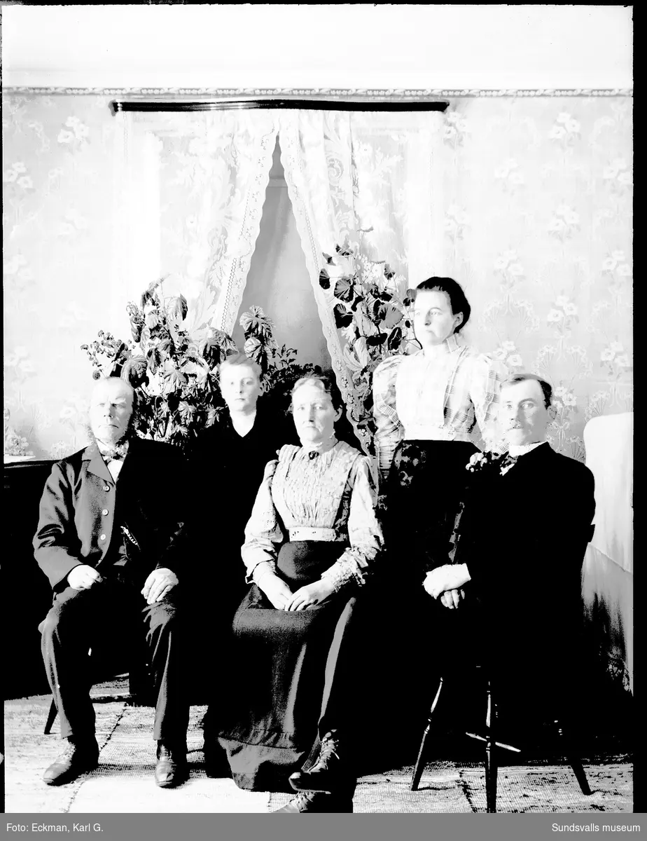 Familjefoto i hemmiljö med två kvinnor, två män och en pojke, Indal. Ur Karl Eckmans samling.