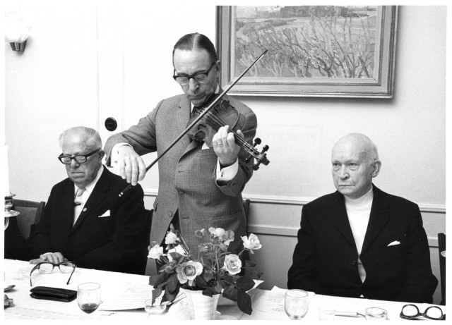 Ordföranden Göte Henriksson, Hudinge 1, leder jubileumsmötet inte
bara med ord utan även med fiolspel. T v lyssnar Harry Litzén,
Stockolm 6 och t h Carl Johan Lundin, Stockholm 16.