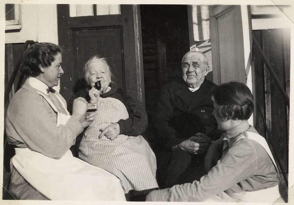 Två sköterskor tillsammans med två åldringar på trappan till ett ålderdomshem, Telestad Svensgård, 1930-tal.
Fr.v.: Ebba Joelsson, Cecilia Elfström, Johannes Nilsson och en okänd sköterska.
