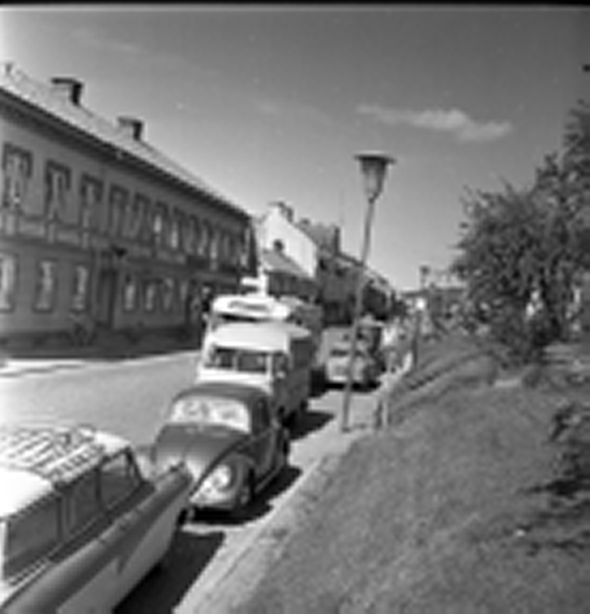 Vy över Brahegatan, i blickfånget är huset på Brahegatan 39 "Norstedtska huset" som på 1960-talet inhyste Grännas postkontor, bank och speceriaffär. Längst med Brahegatan står bilar parkerade. En buss är på väg söderut med texten Jönköping på.