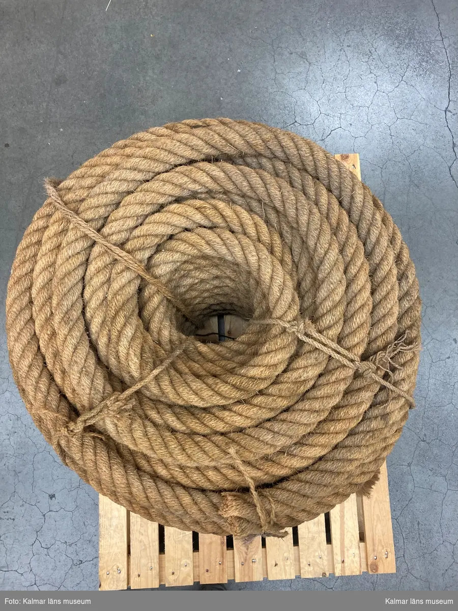 KLM 46537. Tross. En rulle bestående av en lång tross av naturmaterial. Rullen är sammanbunden med rep. Ej tjärat.