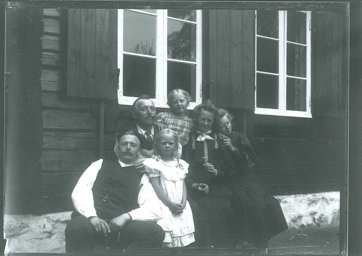 Rydgrenfamilien på Mosjøhytta i Nordmarka. Hyttevinduene har oppslåtte lemmer.
