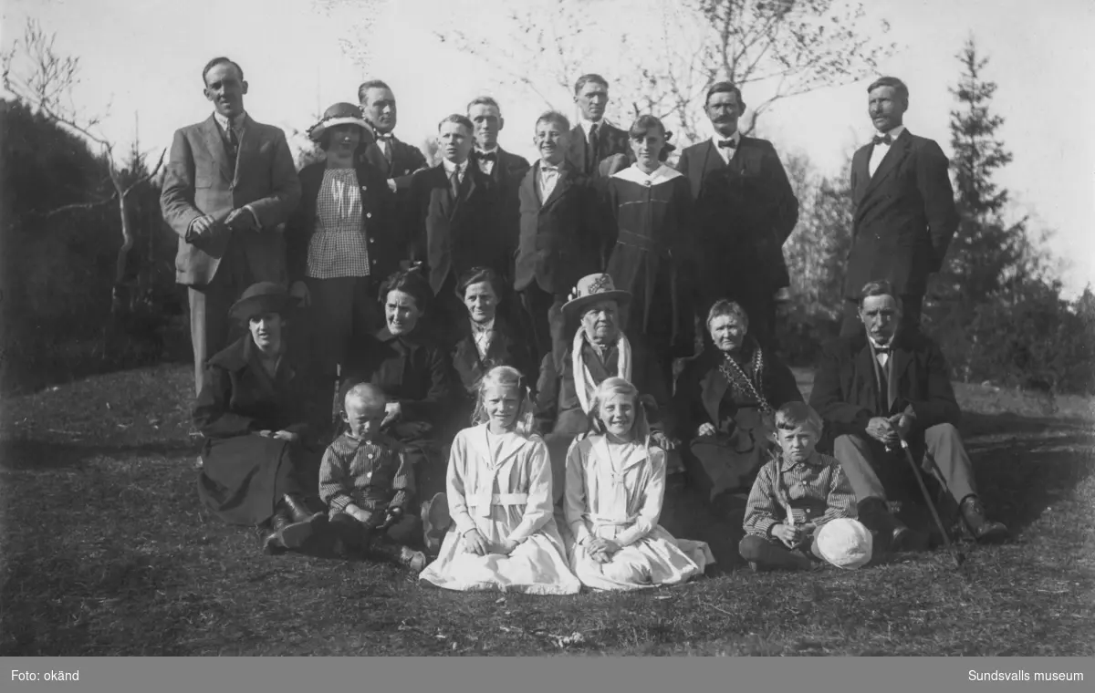 Gruppfoto utomhus med vuxna och barn. På bildens baksida står: 1920. Släktträff på Gumsekullen. Ur en samling som tillhört Kjell Andersson, Svartvik.