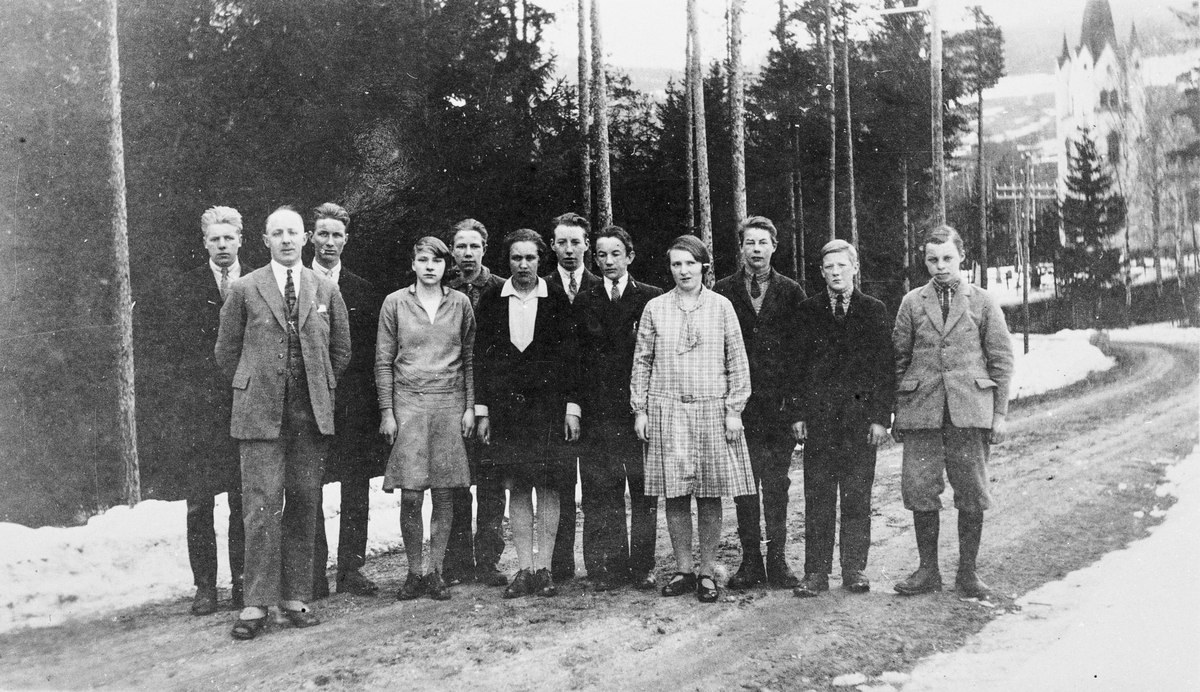 Framhaldsskolen i Eggedal, ca. 1930. 11 elever med lærer Erling Hoff, Eggedal kirke sees i bakgrunnen. Skolen flyttet mellom Sigdal-Eggedal og Krødsherad.