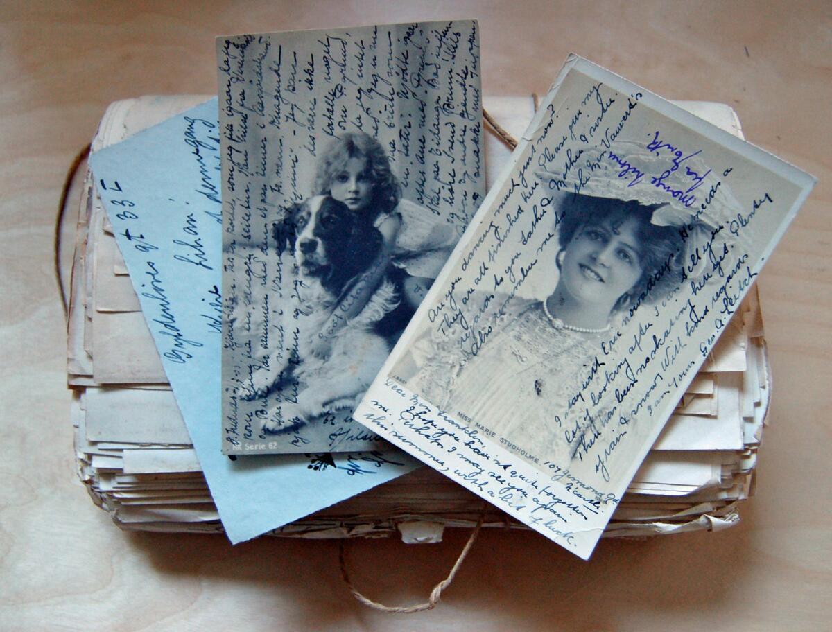 Bildet viser en bunke med gamle brev og postkort