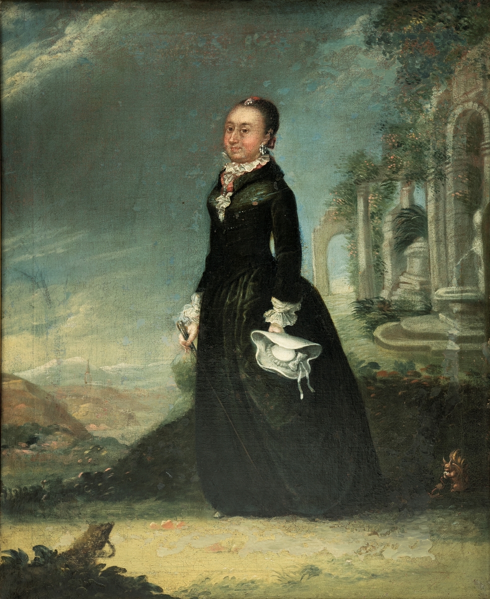 Kvinneportrett, helfigur: Mathea Leuch, f. Collett, vendt mot venstre. Sort kjole, hvit hatt i venstre hånd, vifte i høyre. Ruiner i bakgrunnen.