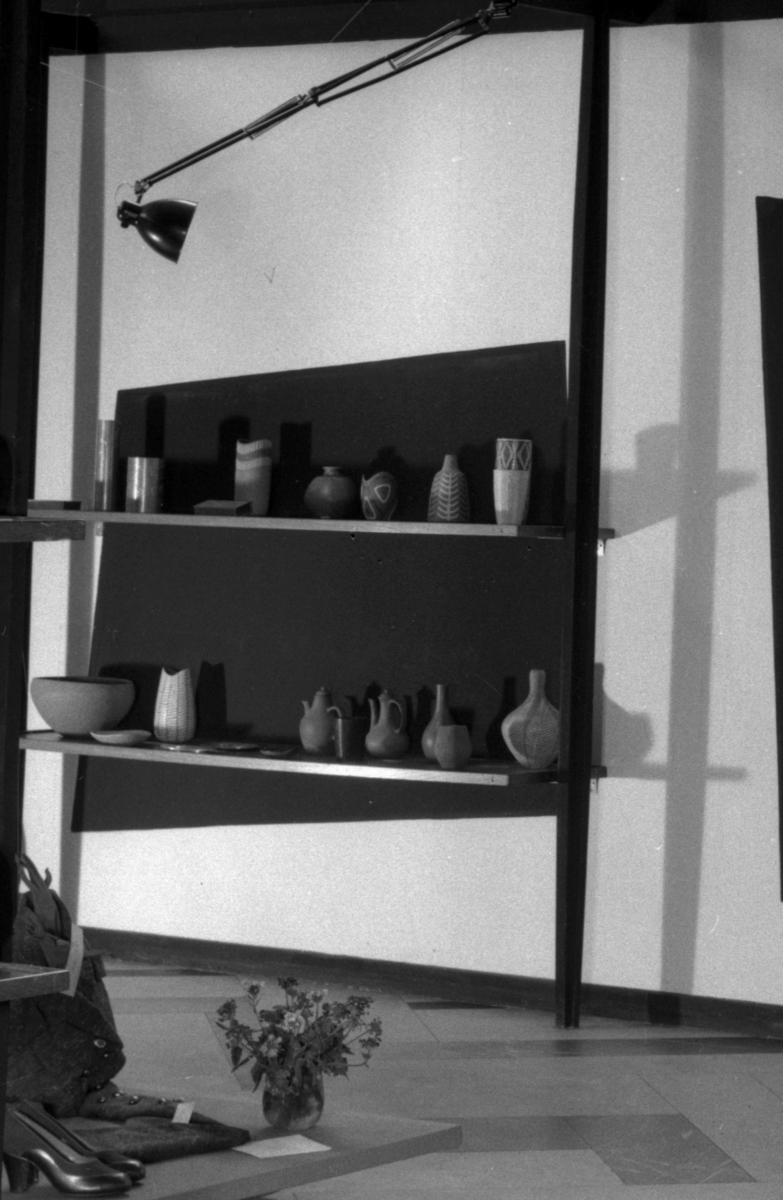 Fra Foreningen Brukskunsts utstilling høsten 1953. To hyller med keramikk, hovedsaklig av Kåre Berven Fjeldsaa, født i Sandnes 1918. (1918-1991).